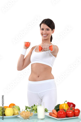 Foto: Woman working out in front of vegetables Woman working out in front of vegetables