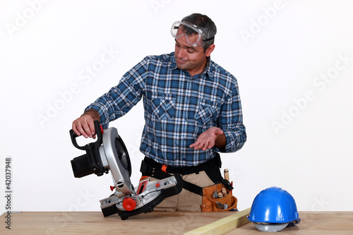 Photo: Man using industrial saw Man using industrial saw