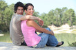 Couple sat by lake