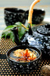Tied green tea blossoms in a tea cup.