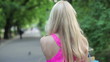 Happy woman with shoping bags walking in park, steadicam shot