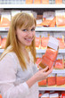 Foto: Happy girl wearing white shirt chooses salmon in store Happy girl wearing white shirt chooses salmon in store