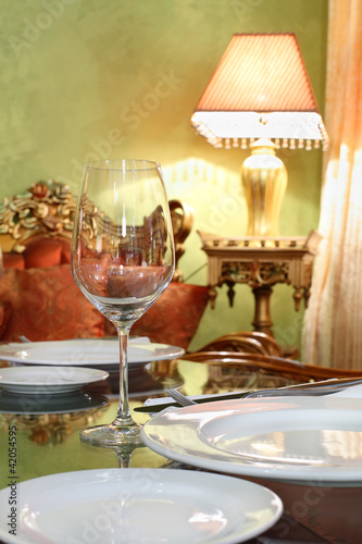 Photo: glass and white plates at table in cozy restaurant glass and white plates at table in cozy restaurant