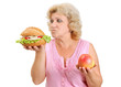 senior woman with hamburger and apple