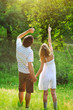 Photo: Young couple holding hands and standing on grass.point to sky Young couple holding hands and standing on grass.point to sky