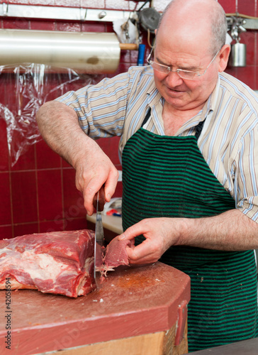 Photo: Butcher cutting steaks Butcher cutting steaks