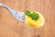 Tortellini on a fork with wooden background