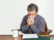 Businessman at Desk Blowing Nose