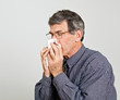 Man with Allergies, Flu or Cold Blowing His Nose