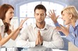 Meditating businessman with arguing colleagues