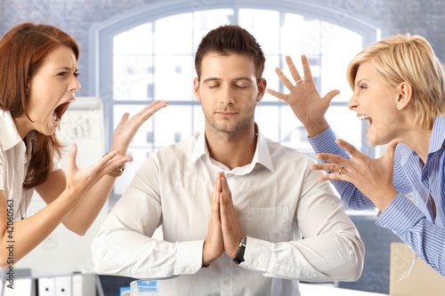 Foto: Meditating businessman with arguing colleagues Meditating businessman with arguing colleagues