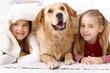 Little sisters and pet dog at home smiling