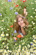 Spring: young woman relaxing in a field of spring flowers