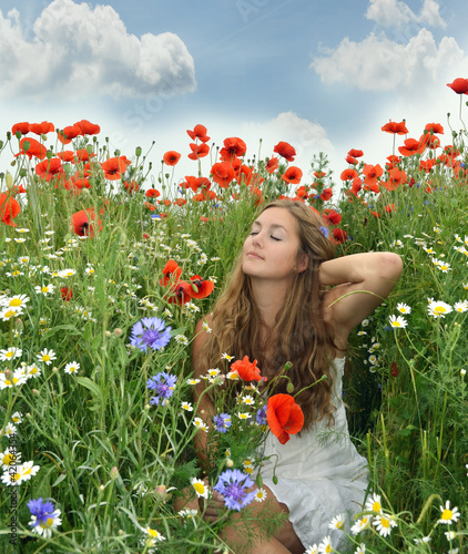 Foto: Angel on vacation in a field with spring flowers Angel on vacation in a field with spring flowers