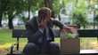 Just fired angry businessman talking on cellphone in the park