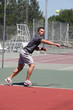 Man playing tennis on a hard court