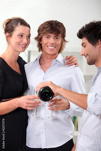 Photo: Three friends drinking champagne at new years Three friends drinking champagne at new years