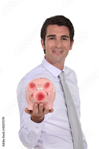 Photo: Man holding a piggy bank Man holding a piggy bank