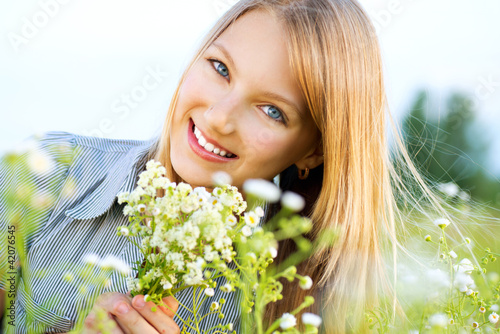 Photo: Beautiful Girl Relaxing outdoors. Happy and Smiling Beautiful Girl Relaxing outdoors. Happy and Smiling