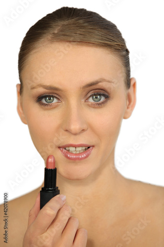 Photo: Woman putting on lipstick Woman putting on lipstick