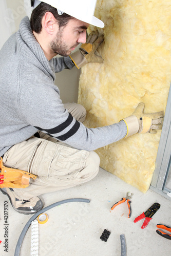Photo: Man installing insulation Man installing insulation