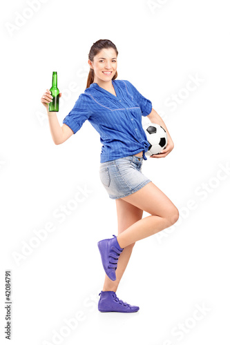 Photo: Happy female fan holding a football and beer Happy female fan holding a football and beer