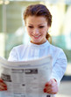 Young beautiful business woman reading newspaper