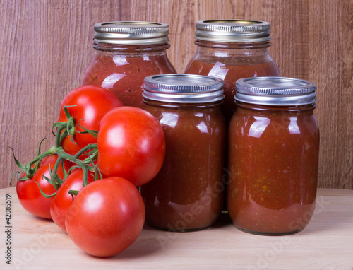 Photo: Tomato sauce in jars and tomatoes Tomato sauce in jars and tomatoes