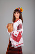 Foto: Attractive woman wears Ukrainian is holding a jug national dress Attractive woman wears Ukrainian is holding a jug national dress