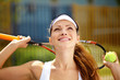 Portrait of a young female tennis player holding a ball and racq
