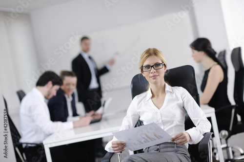 Photo: business woman with her staff in background business woman with her staff in background