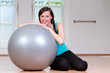 junge Frau mit Gymnastikball zufrieden