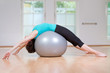 junge frau liegt mit dem Rücken auf gymnastikball