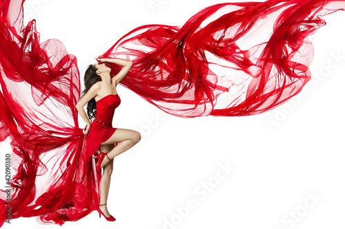 Foto: Beautiful woman dancing in red dress flying on a wind flow over Beautiful woman dancing in red dress flying on a wind flow over