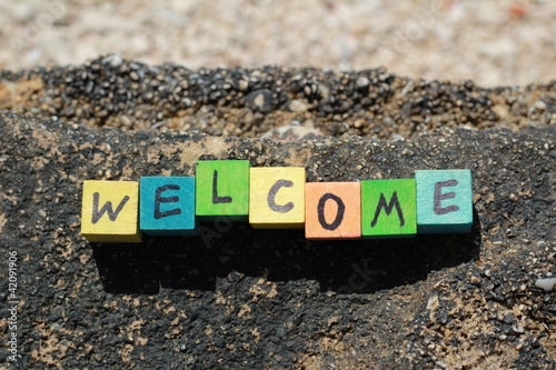 Photo: The word Welcome - written on wood cubes, at the beach The word Welcome - written on wood cubes, at the beach
