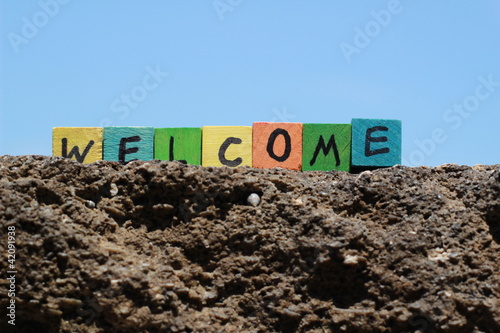 Photo: The word Welcome - written on wood cubes, at the beach The word Welcome - written on wood cubes, at the beach