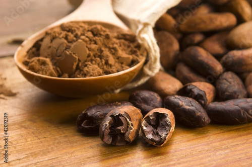 Photo: Cocoa (cacao) beans on natural wooden table Cocoa (cacao) beans on natural wooden table