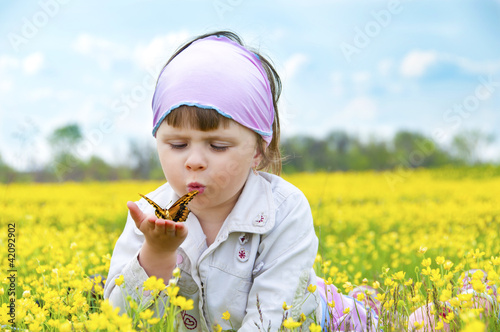 Photo: Little cute girl in a field of beautiful yellow flowers. Little cute girl in a field of beautiful yellow flowers.