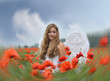 Christmas: Angel on vacation in a field of red poppies