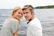 Couple embracing each other on a bridge by a lake