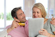 Couple sitting in sofa at home and doing online shopping