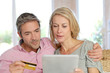 Couple sitting in sofa at home and doing online shopping