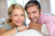 Middle aged couple relaxing in sofa at home
