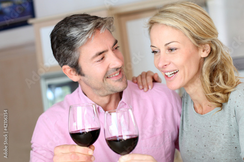 Foto: Happy couple in kitchen drinking red wine Happy couple in kitchen drinking red wine