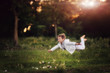 The boy in a white suit soars over a grass