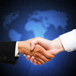 Foto: Handshake vor Weltkarte Handshake vor Weltkarte