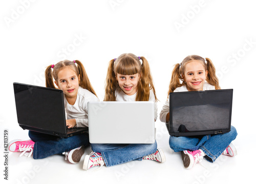 Photo: Three attractive girl using a laptop Three attractive girl using a laptop