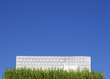 white keyboard on the grass and blue sky