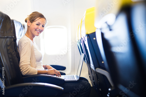 Foto: Young woman on board of an airplane Young woman on board of an airplane