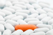 Individuality: Orange pill between white ones